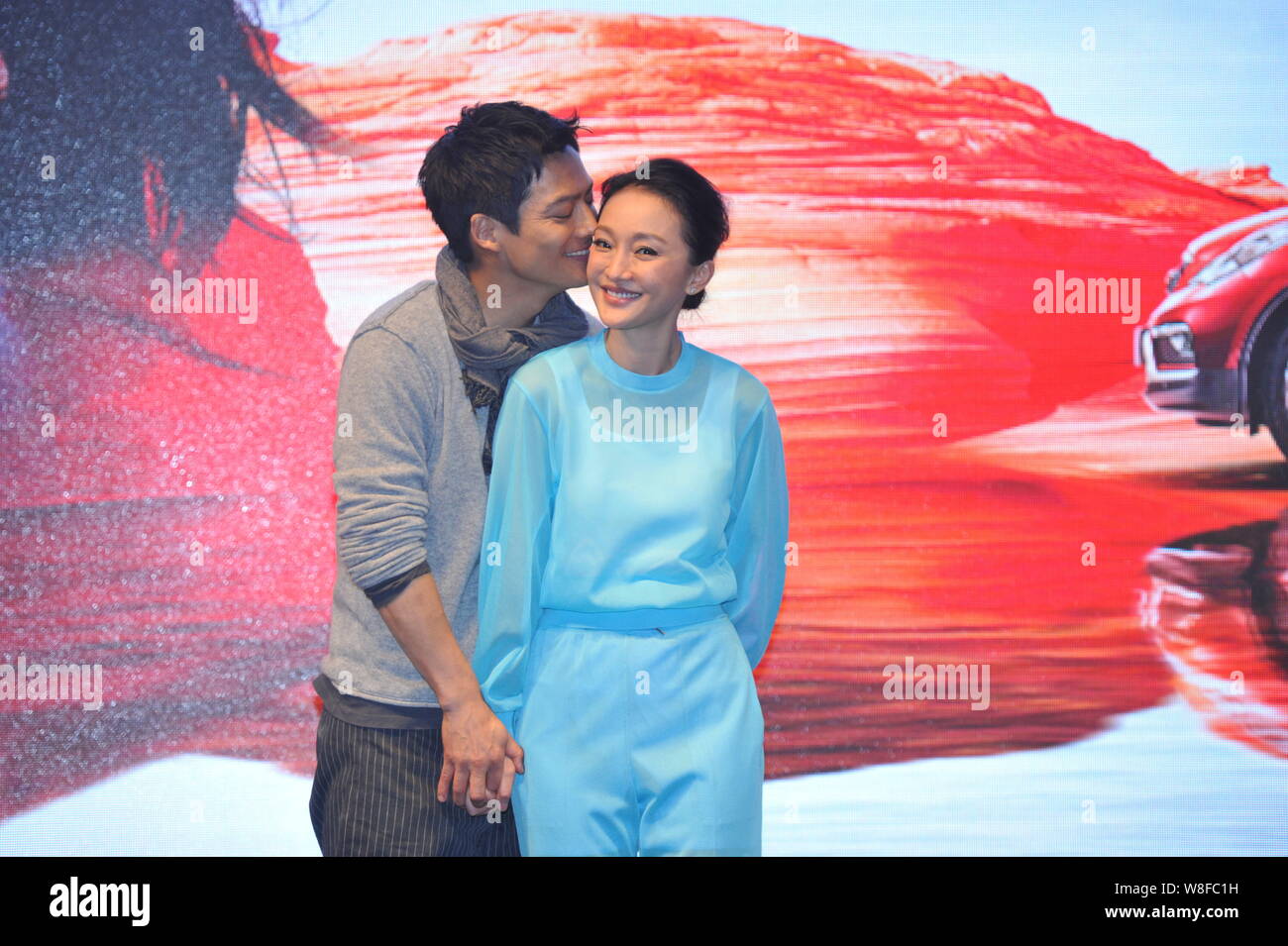 Chinesische Schauspielerin Zhou Xun, rechts, wird von ihren amerikanischen Schauspieler Ehemann Archie Kao während einer Premiere für die micro Film 'Dream Escape' zu Promo küsste Stockfoto