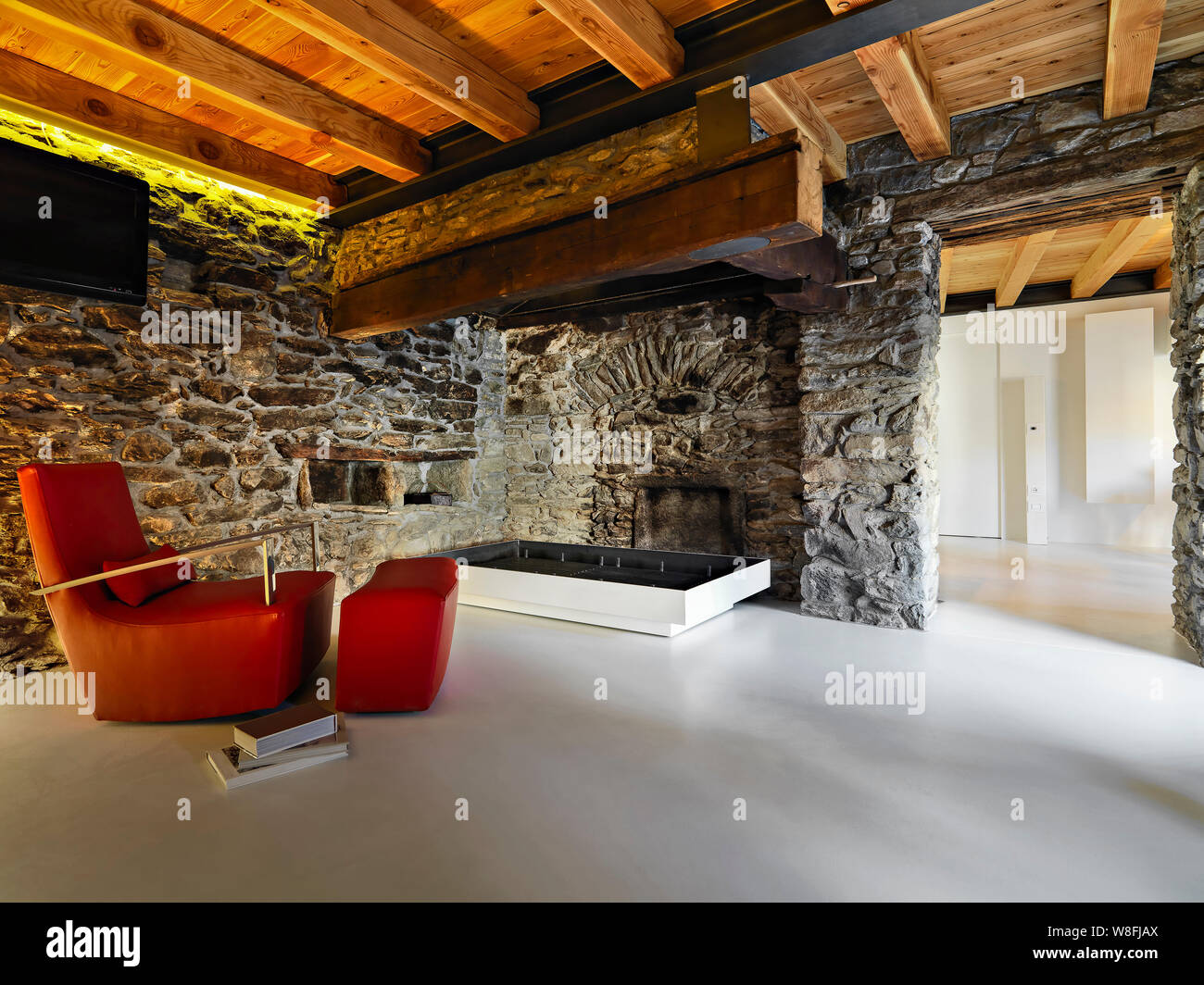 Innenaufnahmen von einem rustikalen Wohnzimmer mit Harz, im Vordergrund die Ledersessel und die rustikalen Kamin die Wände aus Stein gemacht sind Stockfoto