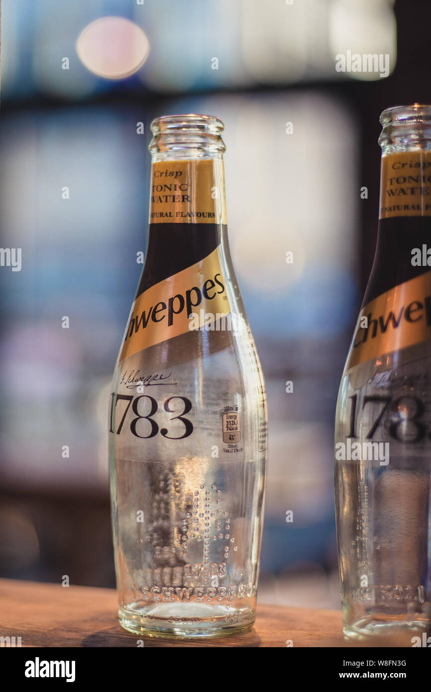 Zwei leere Schweppes Tonic Water Glas Flaschen in der Bar Gegenlicht der Sonne. Stockfoto