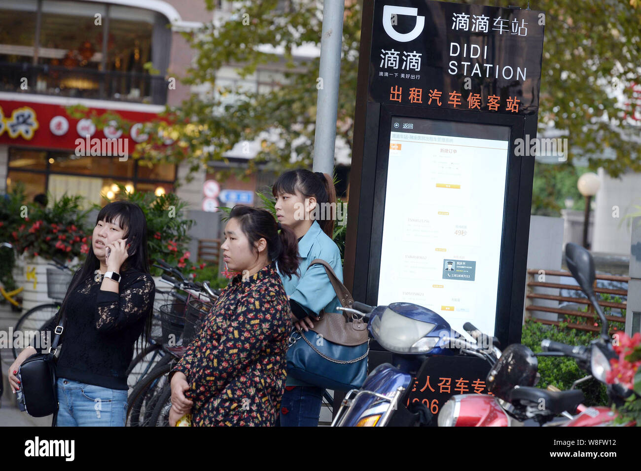Chinesische Passagiere warten Autos an einem Taxistand von Taxi-hageln app Didi in Shanghai, China, 15. Oktober 2015. Chinesische beliebte Taxi - hageln App hat Stockfoto