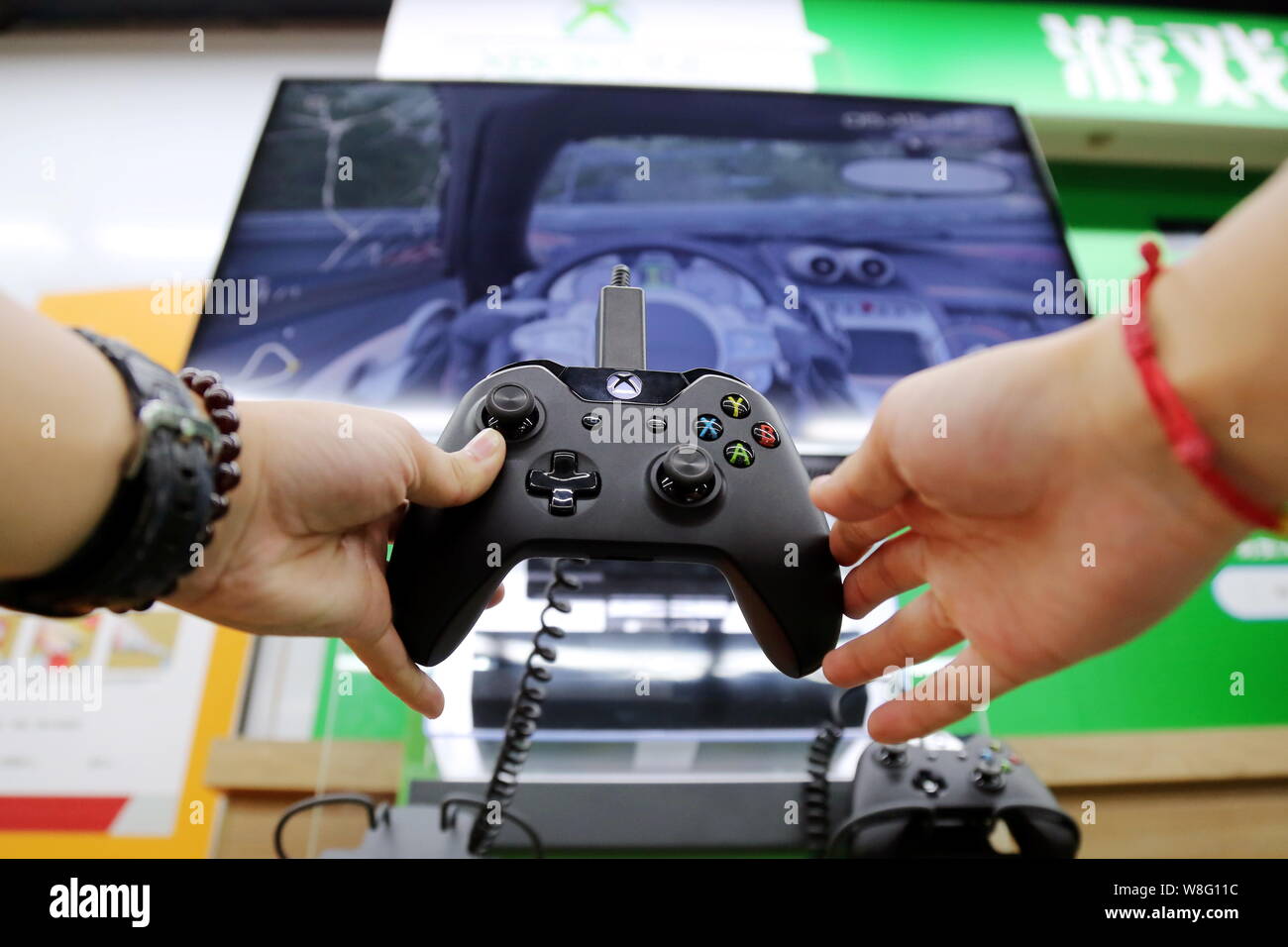 ---- Ein Besucher spielt eine elektronische Rennspiel auf einem Microsoft Xbox Spielkonsole in einem Geschäft in Shanghai, China, 29. September 2014. China wird Stockfoto