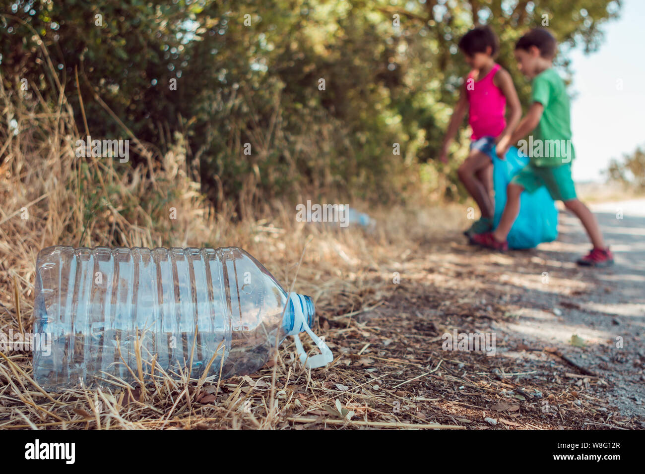 Kinder Abholung Müll im Wald mit einer Plastiktüte. Ehrenamt, Nächstenliebe und Ökologie Konzept. Stockfoto
