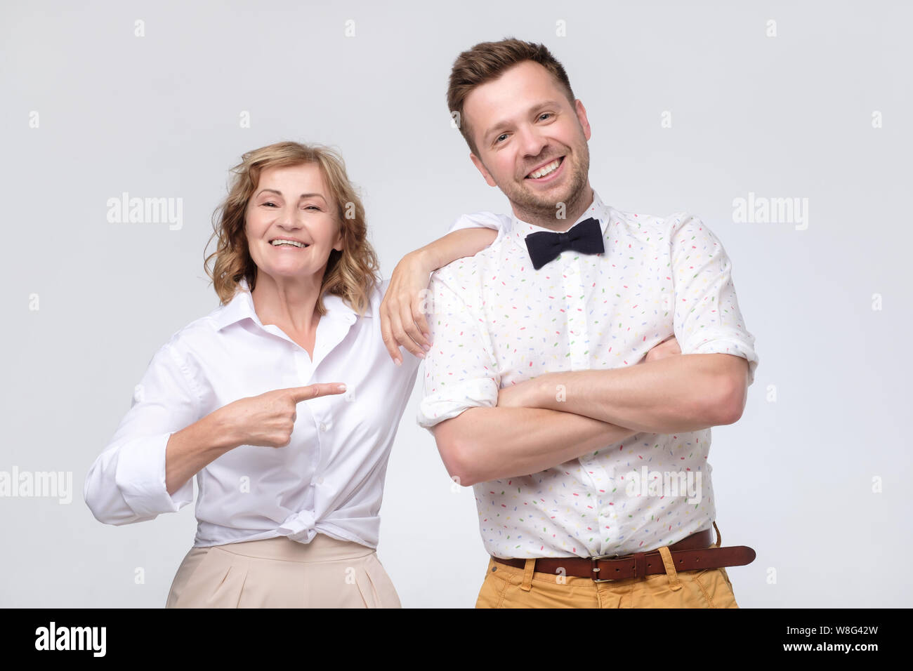 Reife Frau boss verweist auf junge männliche Kollegen, ihn zu loben. Stockfoto