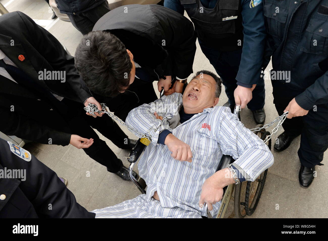 Die chinesische Polizei und Gericht Offiziere den Patienten entfernen mit dem Beinamen von Rollstuhl aus Peking Jingmei Group General Hospital in Peking, China, 10. Feb. Chen Stockfoto