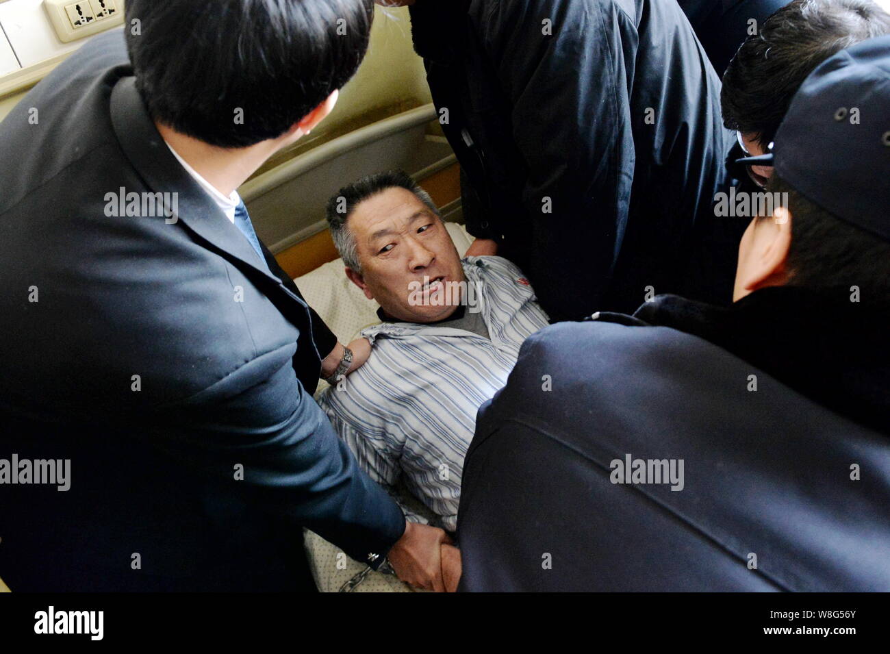 Die chinesische Polizei und Gericht Offiziere versuchen Sie zu befreien und den Patienten entfernen Zunamen Chen aus dem Bett in Peking Jingmei Gruppe Allgemeine Krankenhaus in Beijin Stockfoto