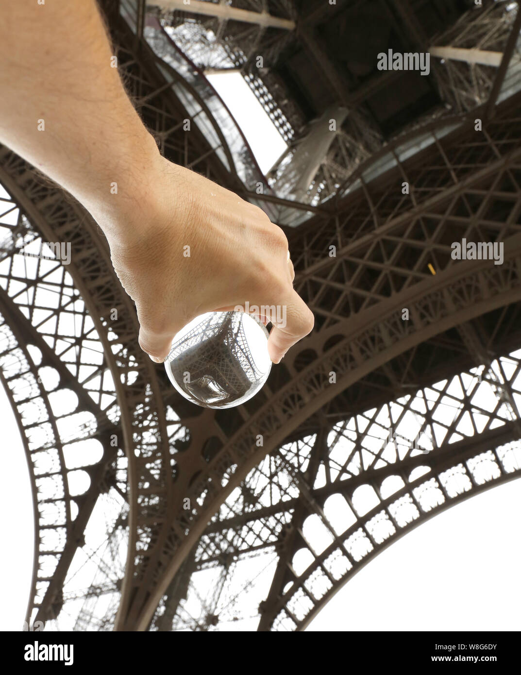 Einen Mann mit einem großen Kristall Kugel unter dem Eiffelturm in Paris Frankreich Stockfoto