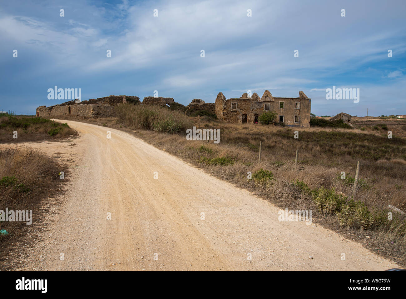 Schmutz Straße, die zu einem verlassenen Haus aus Stein Stockfoto