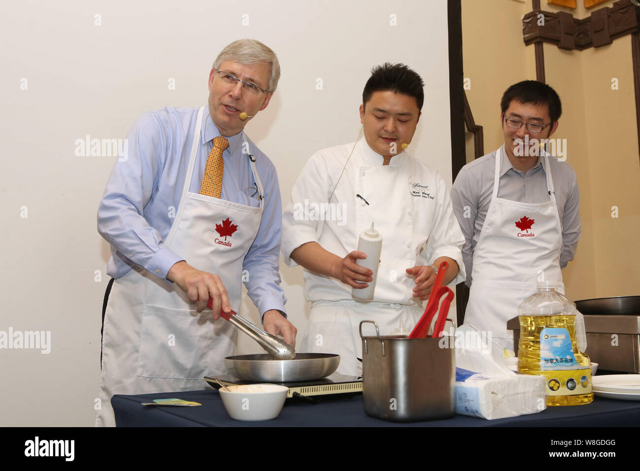 Kanadische Botschafter in China Kerl Saint-Jacques, Links, zeigt seine Kochkünste als Barry Zhu Pengcheng, rechts, Chief Merchandising Officer von yihao Stockfoto