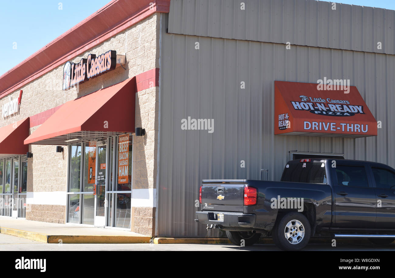 Mann in einem Pickup Truck wartet auf eine Pizza im Little Caesars Pizza Store Herbstanfang Fenster in Yazoo Mississippi - April 2019 Stockfoto