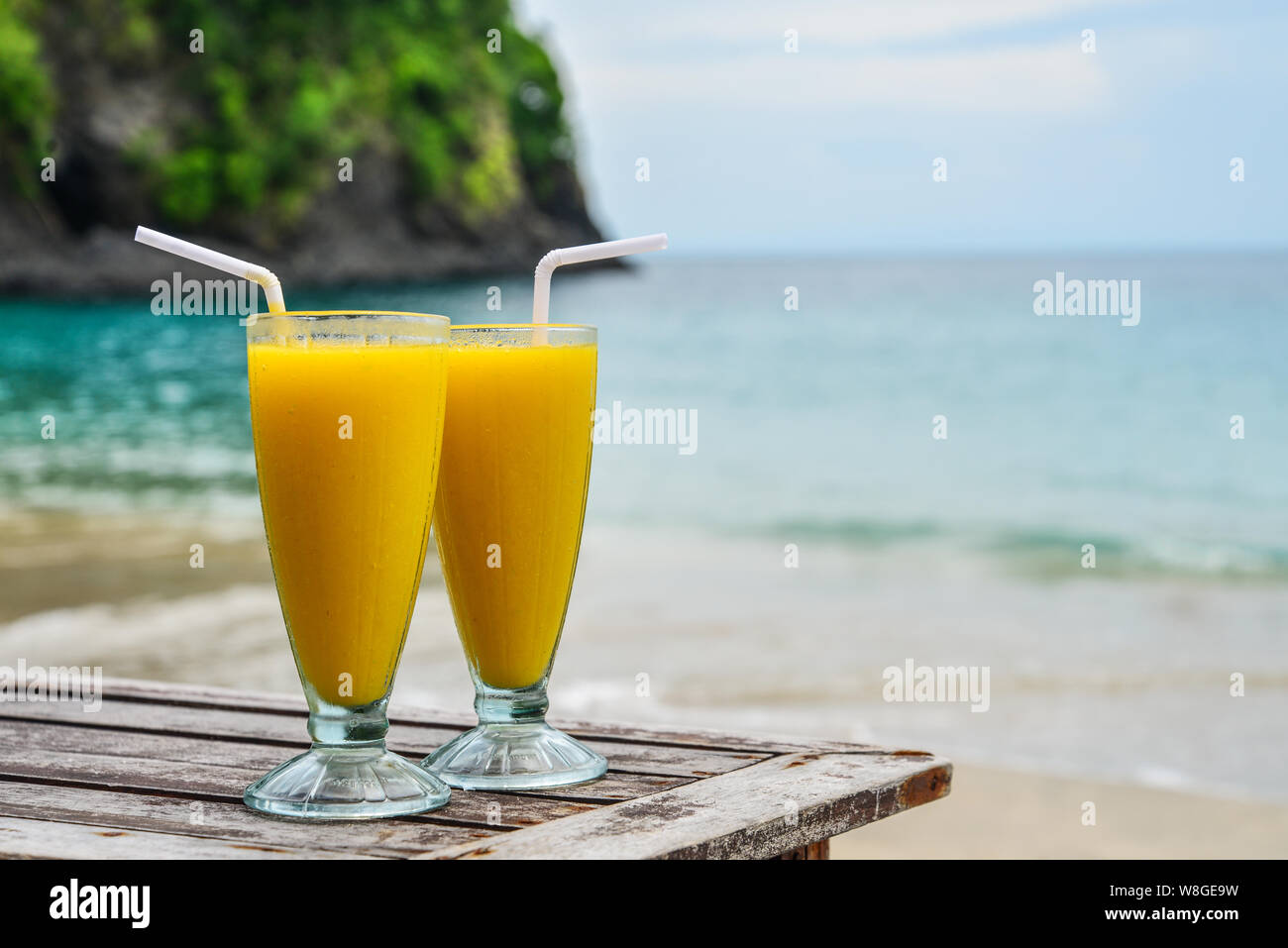 Iced Glas mit Mango smoothies am Strand auf der Insel Bali Stockfoto