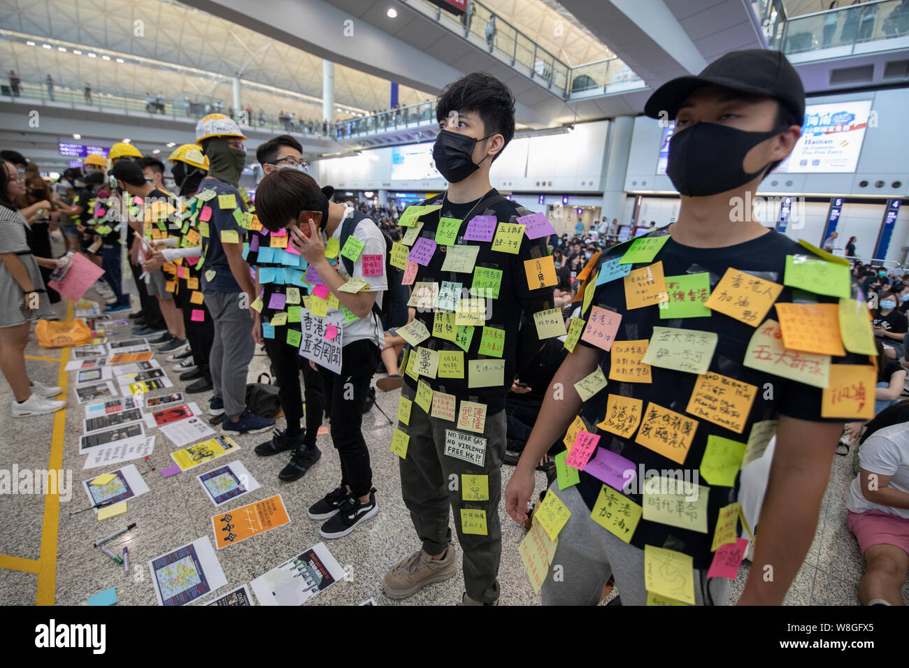 Die demonstranten als menschliche Lennon-mauer für andere Nachrichten auf ihren Körper während der Demonstration in den Flughafen zu veröffentlichen. Tausende Demonstranten nahmen in der Ankunftshalle des internationalen Flughafen Hong Kong unter der Bezeichnung "Grüße aus HKers Versammlung" die Aufmerksamkeit der internationale Reisende, die gerade in Hongkong über die aktuellen Unruhen in der Stadt gelandet zu fangen. Stockfoto