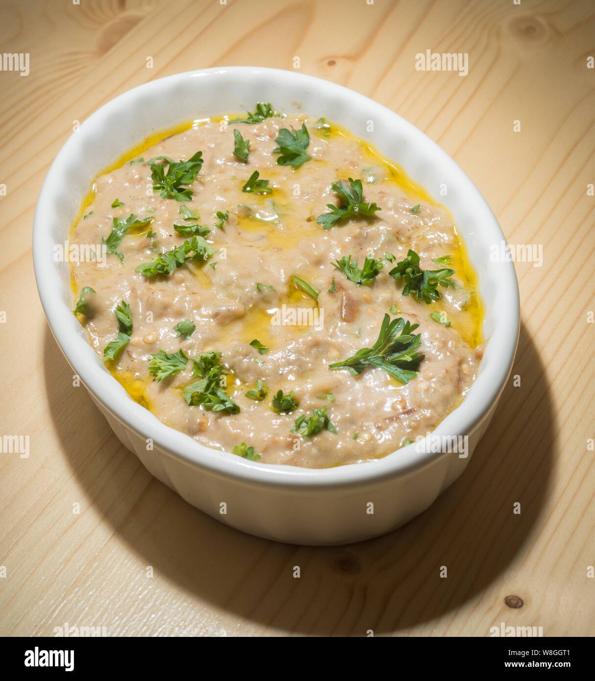 Gebratene Auberginen Dip (Baba Ghanoush) mit Zutaten wie Aubergine, Petersilie, Bohnenkraut und Olivenöl Stockfoto
