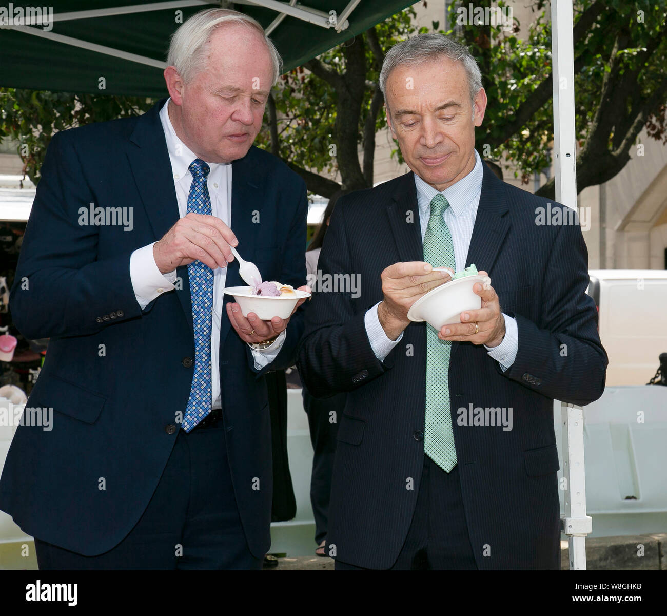 Männer in Anzügen Eis essen am Nationalen Eis Tag Feier war des US-Außenministeriums Agrculture gehalten Stockfoto
