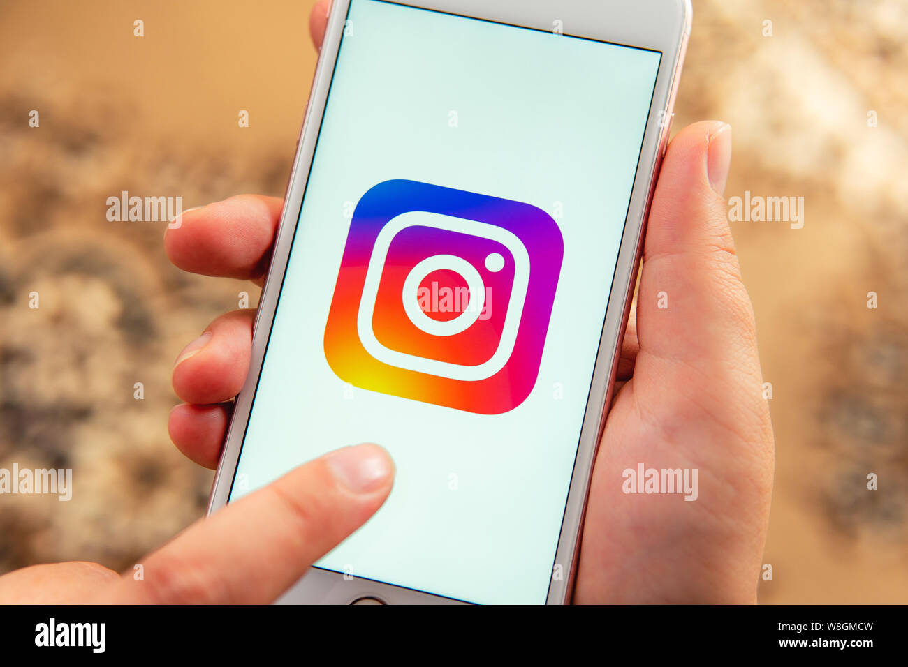 Weibliche hand mit Apple Handy mit Logo von social media Instagram auf dem Bildschirm. Social media Symbol. Kann als illustrative für Marketing Konzept verwendet werden. Stockfoto