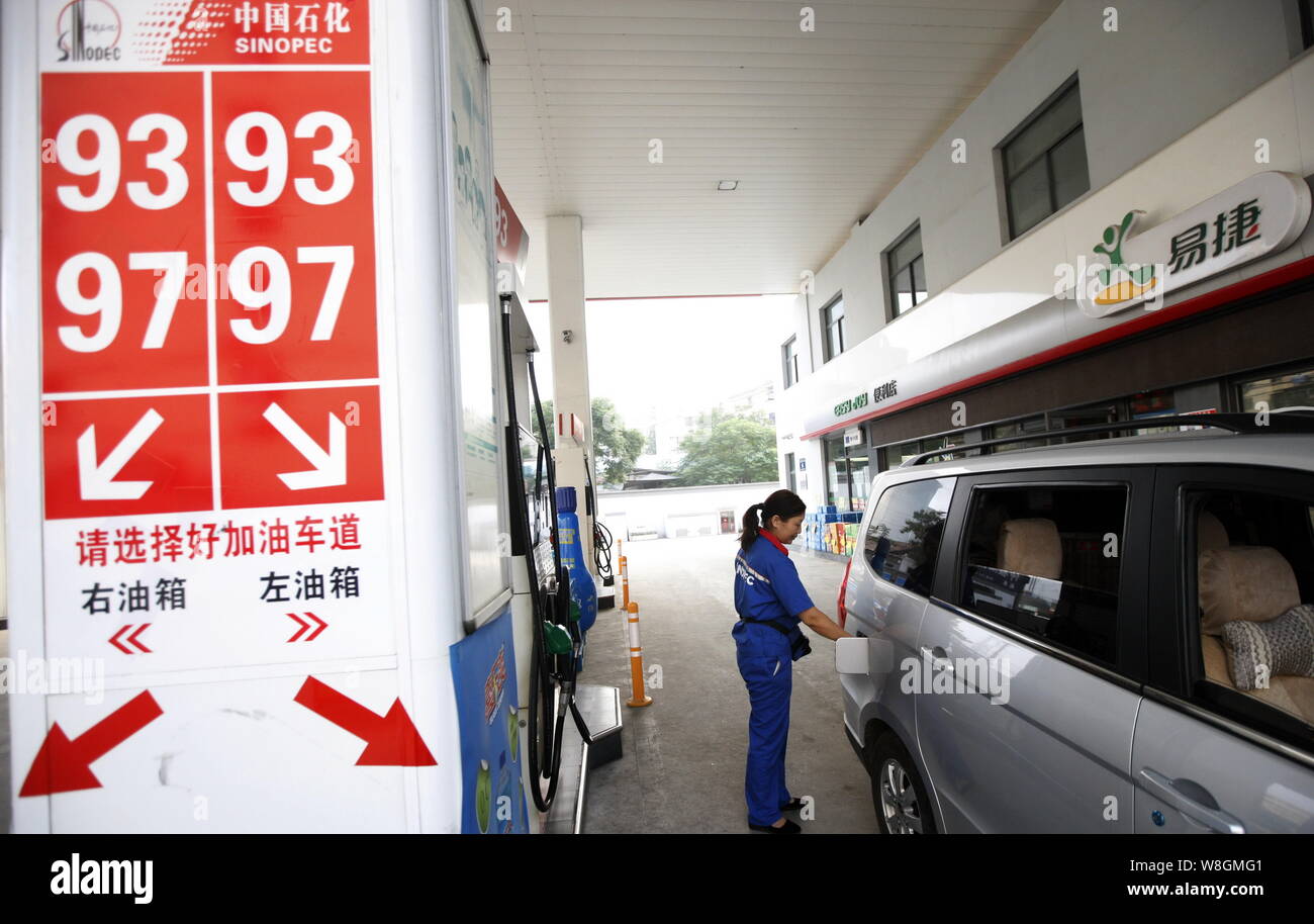 ---- Ein chinesischer Arbeiter tankt ein Kleinbus an einer Tankstelle von Sinopec in Stadt Huaibei, der ostchinesischen Provinz Anhui, 22. Juli 2015. Energieriese Si Stockfoto