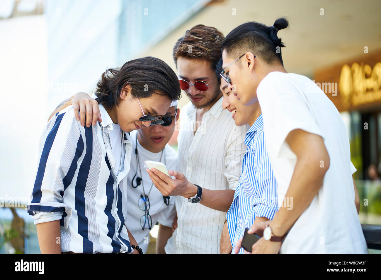 Jungen asiatischen erwachsene Männer mit Social Media am Mobiltelefon zusammen suchen Stockfoto
