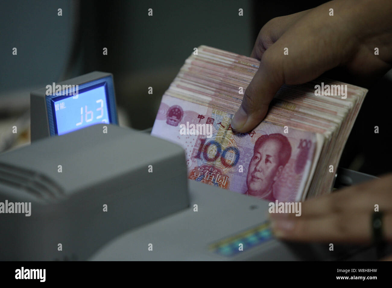 ---- Eine chinesische Angestellte verwendet eine Cash - Zählmaschine RMB (Renminbi) Yuan Banknoten bei einer Bank in der Stadt Huaibei zu zählen, der ostchinesischen Provinz Anhui, 1. Stockfoto