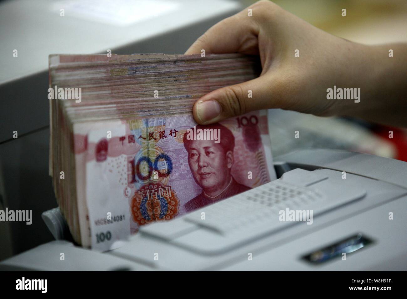 ---- Eine chinesische Angestellte verwendet eine Cash - Zählmaschine RMB (Renminbi) Yuan Banknoten bei einer Bank in der Stadt Huaibei zu zählen, der ostchinesischen Provinz Anhui, 26. Stockfoto
