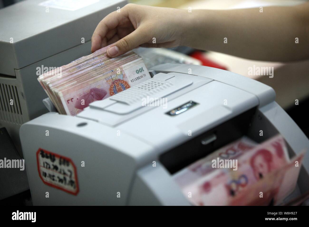 ---- Eine chinesische Angestellte verwendet eine Cash - Zählmaschine RMB (Renminbi) Yuan Banknoten bei einer Bank in der Stadt Huaibei zu zählen, der ostchinesischen Provinz Anhui, 26. Stockfoto