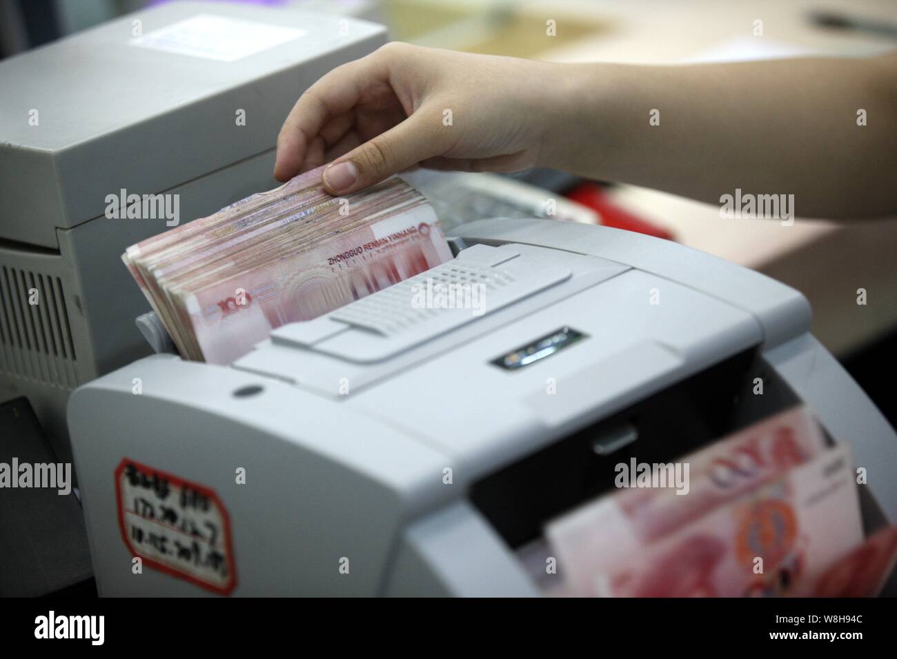 ---- Eine chinesische Angestellte verwendet eine Cash - Zählmaschine RMB (Renminbi) Yuan Banknoten bei einer Bank in der Stadt Huaibei zu zählen, der ostchinesischen Provinz Anhui, 26. Stockfoto