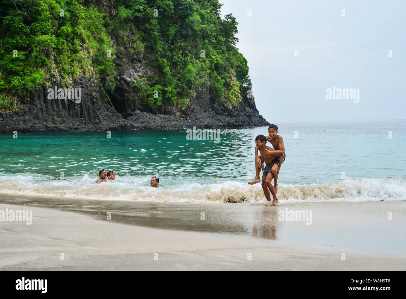 BALI, Indonesien - Januar 14, 2018: Kinder spielen am tropischen Strand auf Bali in der Nähe von knowen Chandidasa, wie White Sand Beach Stockfoto