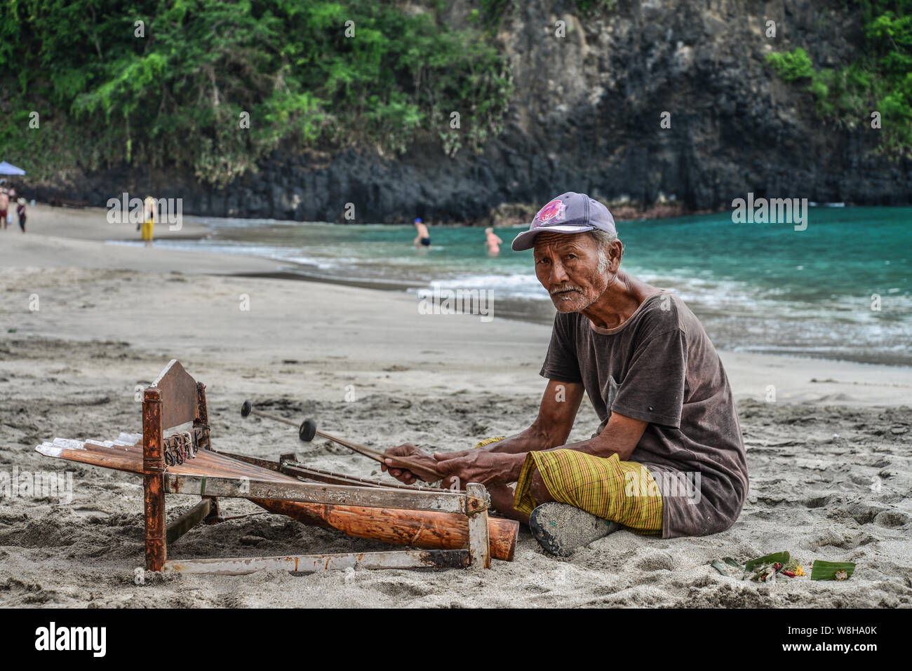 BALI, Indonesien - Januar 14, 2018: Alter Mann spielt eine traditionelle balinesische Instrument gambang am White Sand Beach, Bali, Indonesien Stockfoto