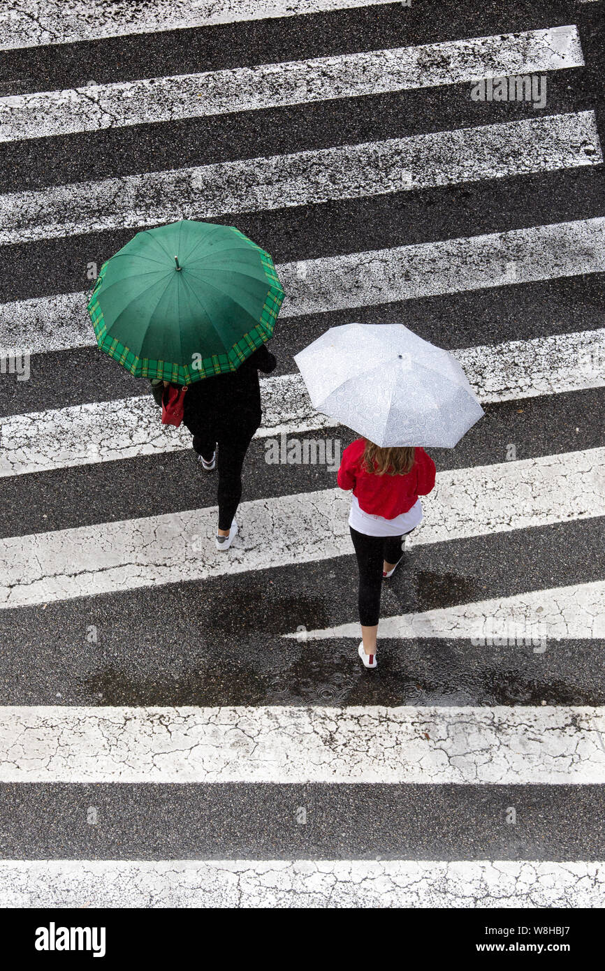 Szene von zwei Frauen mit Mode Dach über dem Bürgersteig. Ansicht von oben. Regentag Konzept Stockfoto