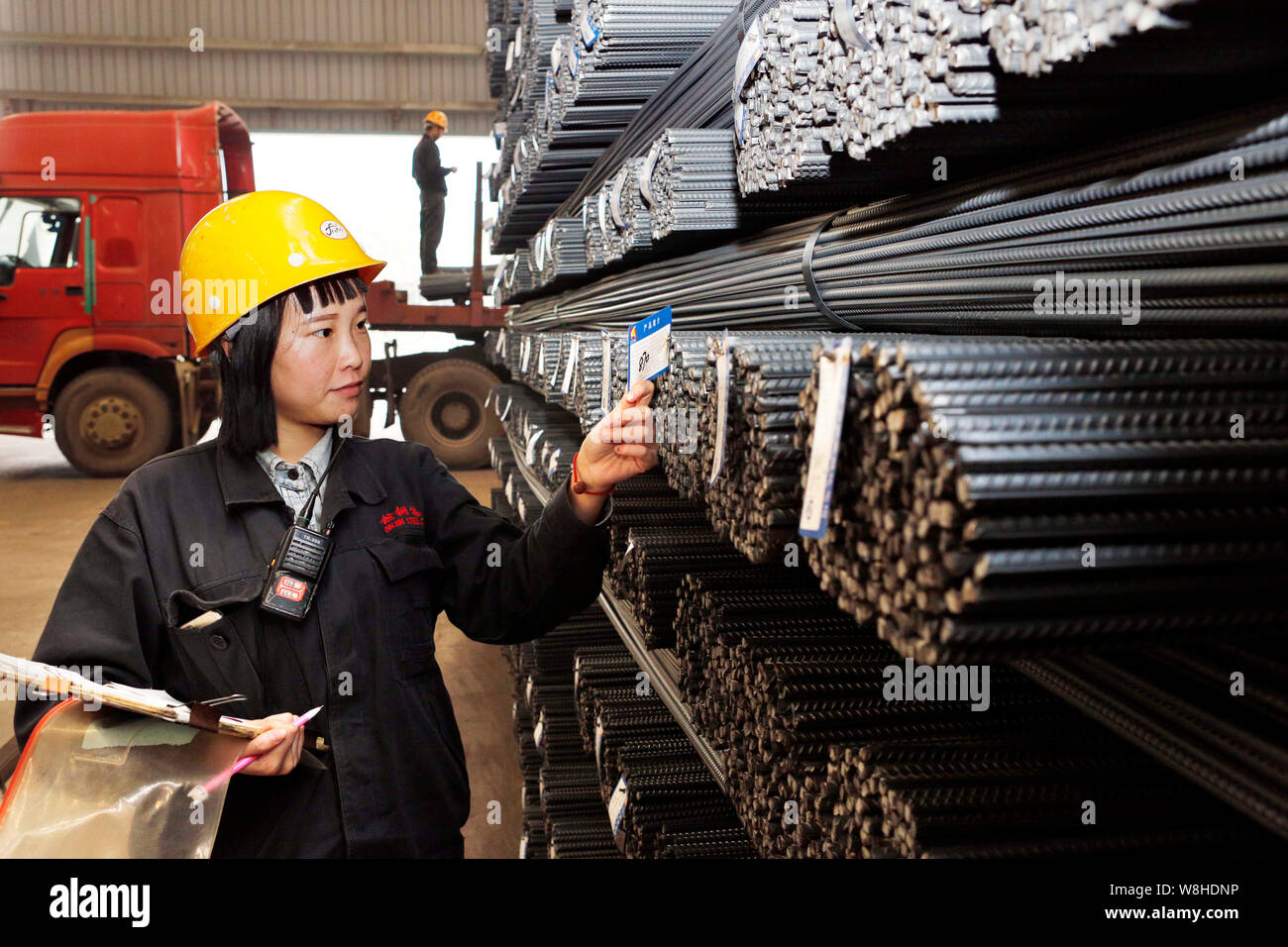 ---- Eine weibliche chinesischer Arbeiter prüft Etiketten vom Verstärken von Stahl Stäbe im Lager eines Stahlwerks in Lanzhou, China Jiangsu pr Stockfoto