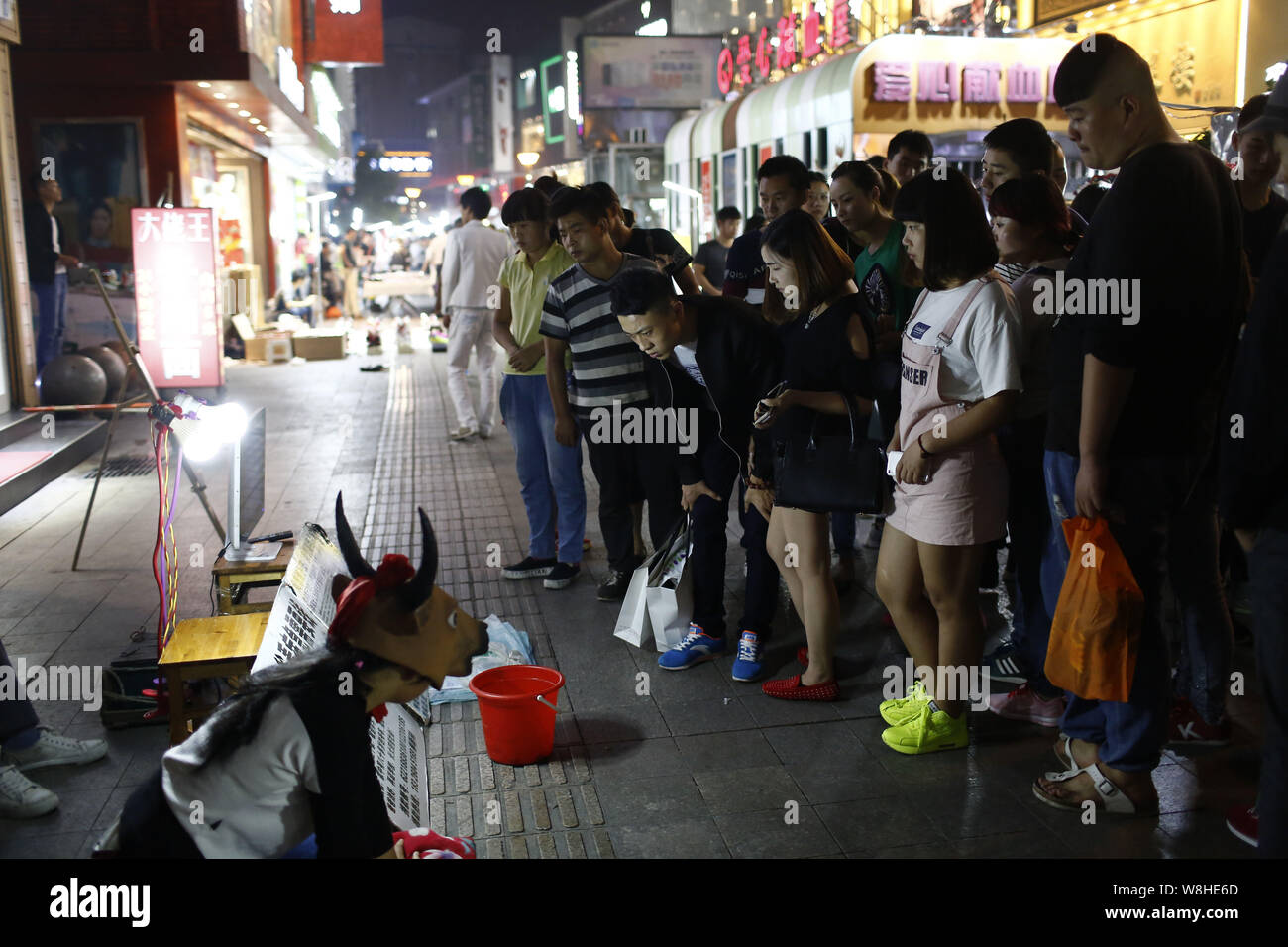 Der 15-jährige Hao Elhazray ahmed Hamadi (Alias), Links, in Kuh Kostüm gekleidet, bettelt auf der Straße Geld für medizinische Kosten ihres Vaters in Hefei City zu erhöhen, Stockfoto