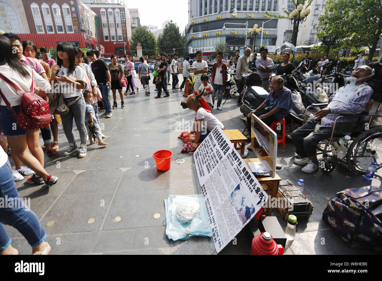 Der 15-jährige Hao Elhazray ahmed Hamadi (Alias), Center, in Kuh Kostüm gekleidet, bettelt auf der Straße Geld für medizinische Kosten ihres Vaters in Hefei City zu erhöhen Stockfoto
