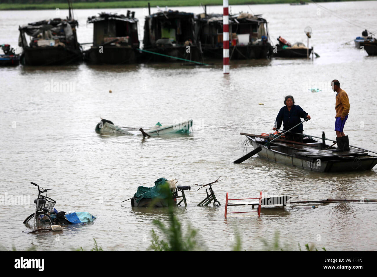 Lokale chinesische Bewohner fahren Sie mit dem Boot auf einer überfluteten Fluss durch starken Regen in Shangrila Stadt verursacht, der ostchinesischen Provinz Anhui, 30. Juni 2015. Überschwemmungen und er Stockfoto