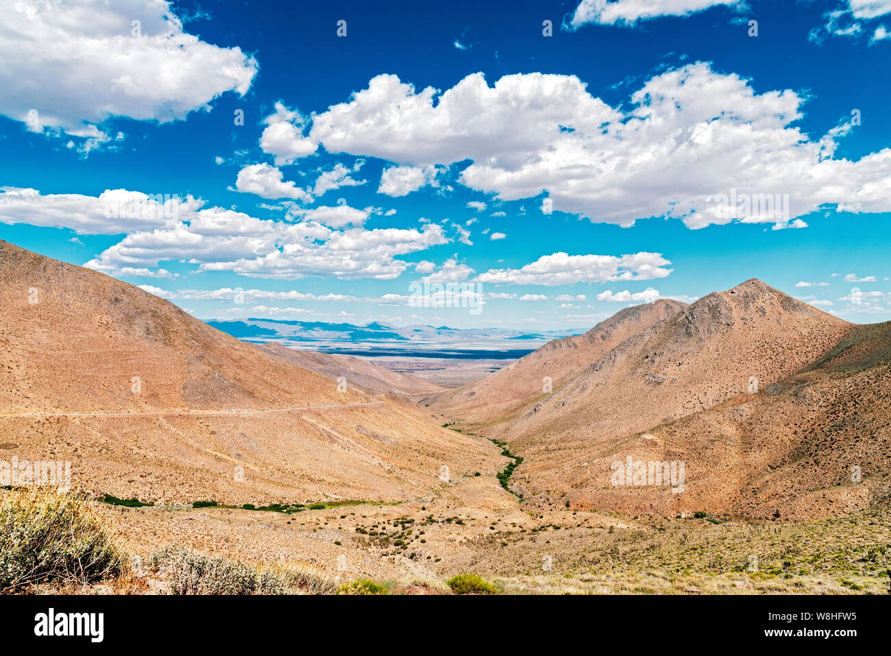 Blick über Desert Canyon im Tal unten unter strahlend blauen Himmel mit flauschigen weissen Wolken. Stockfoto