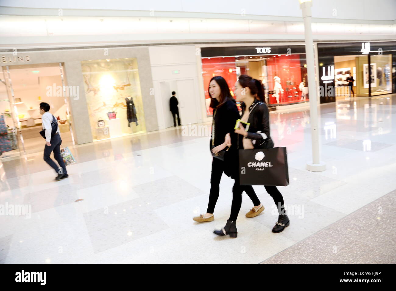 --FILE - eine moderne, junge Frau geht mit einem Freund nach dem Shopping in der modeboutique von Chanel im Plaza 66 Shopping Mall in Shanghai, China, 20. Stockfoto
