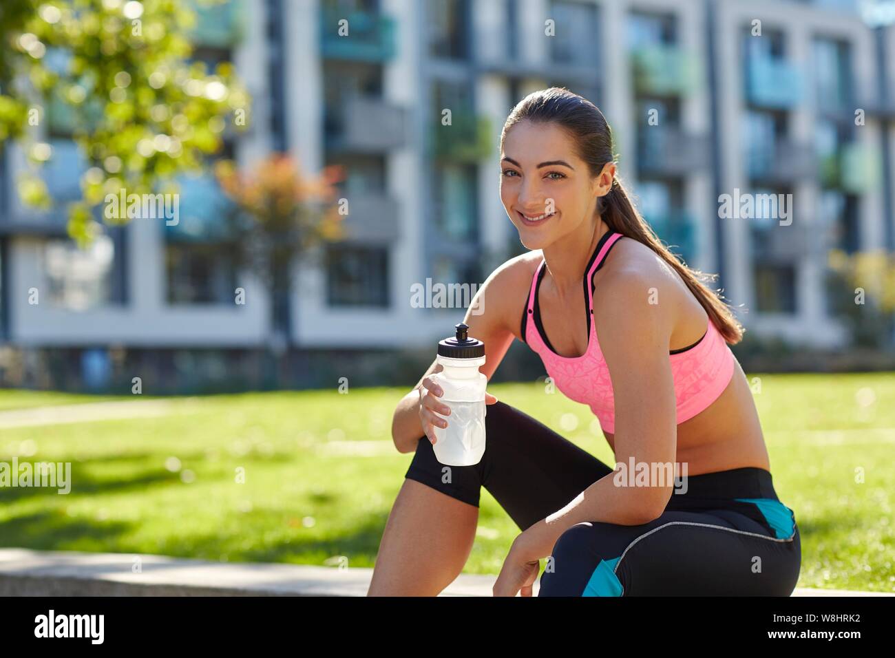 Junge Frau in Sportbekleidung Holding eine Wasserflasche. Stockfoto