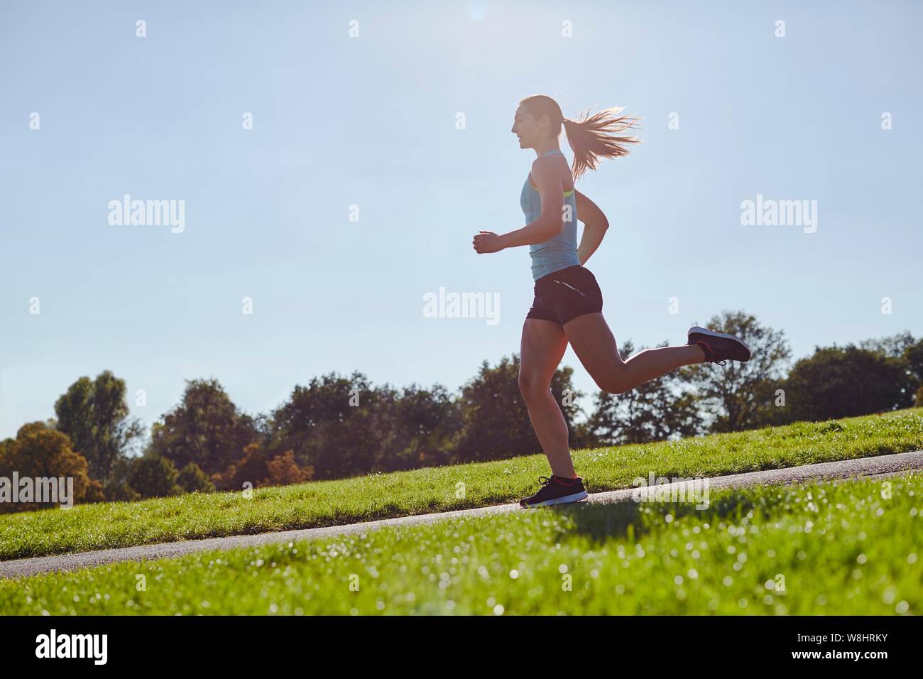 Junge Frau joggen auf einem Pfad. Stockfoto
