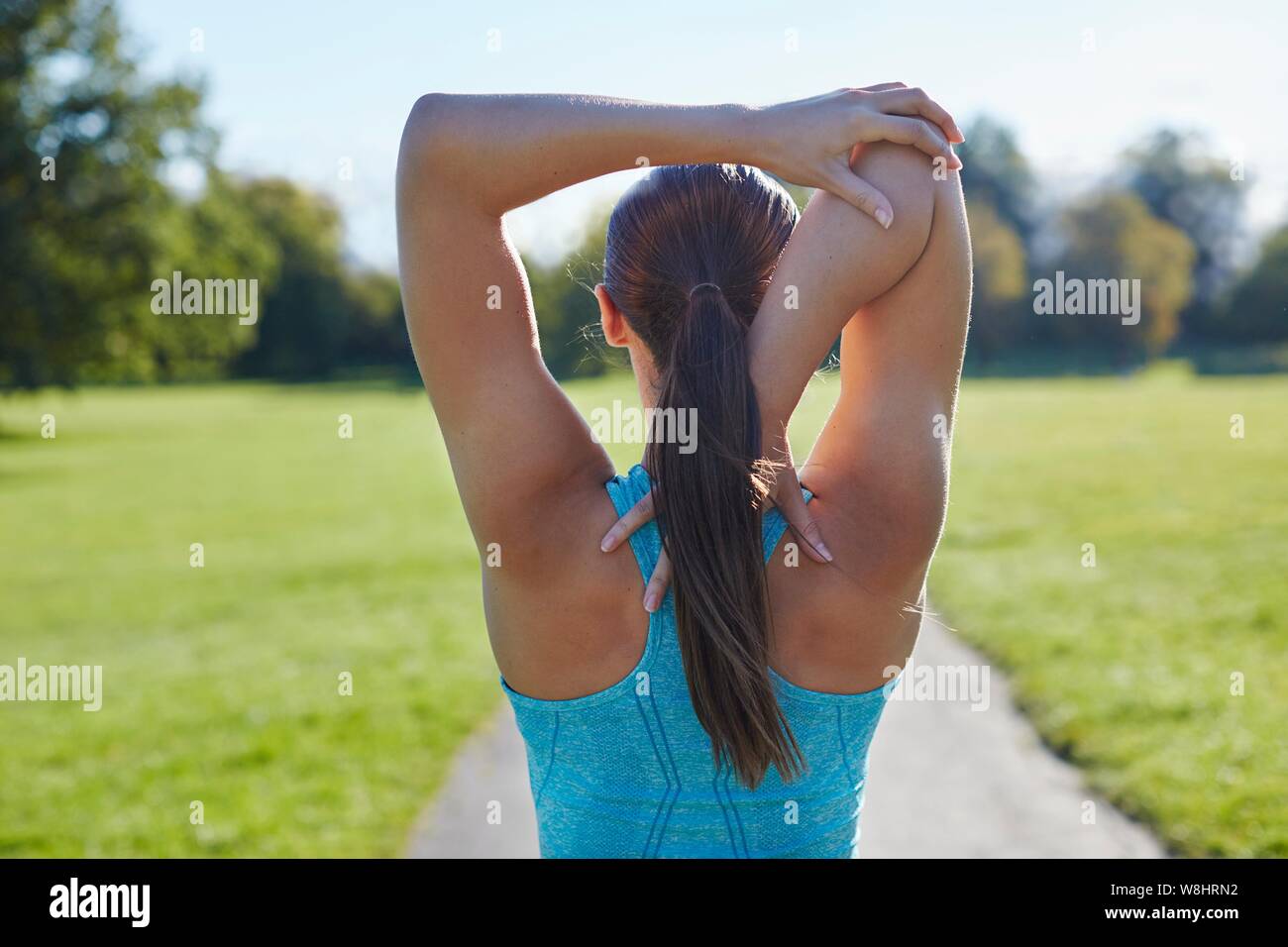 Junge Frau stretching arm, Ansicht von hinten. Stockfoto