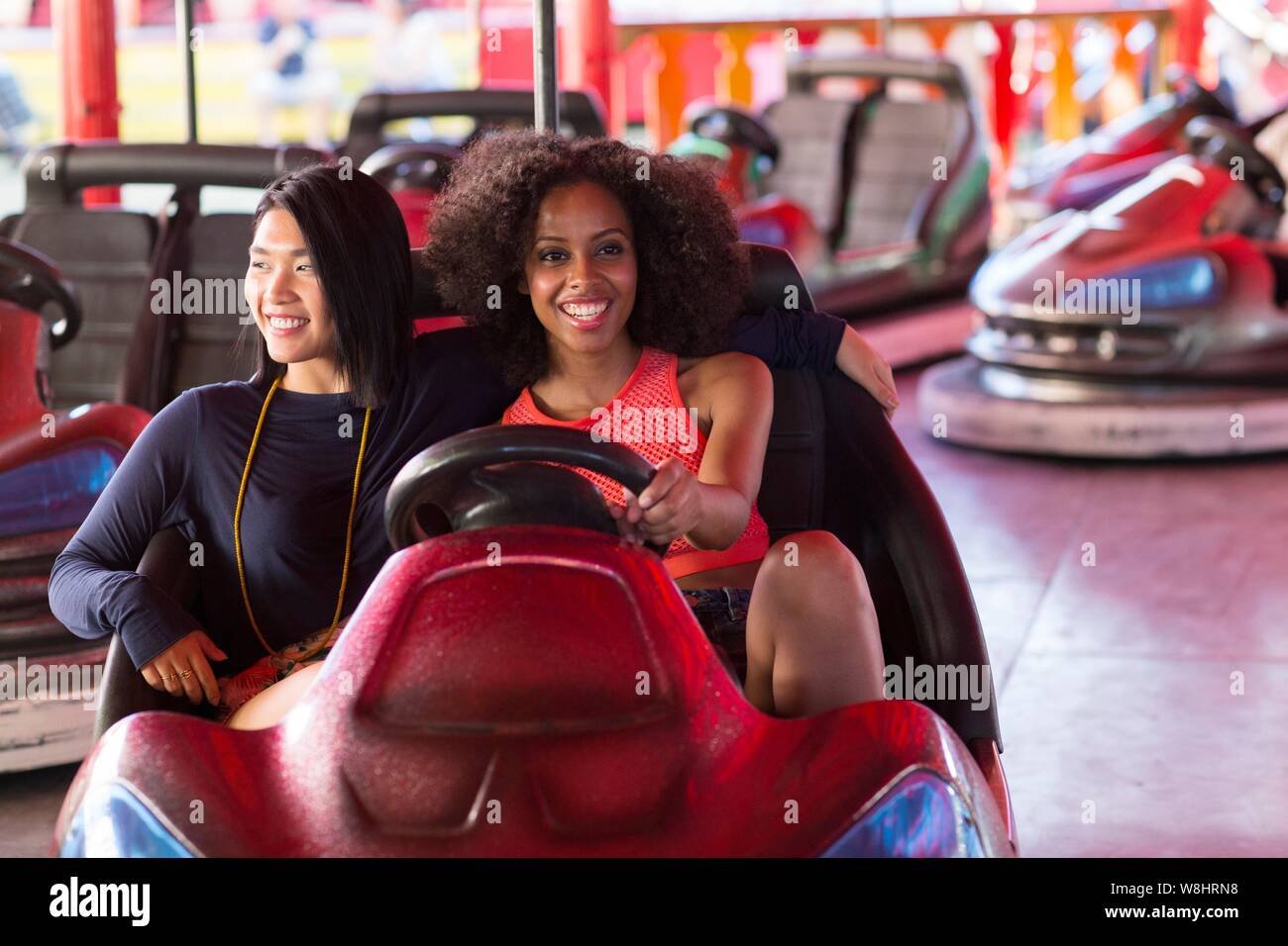 Zwei junge Frauen am Stoßfänger Auto an Kirmes. Stockfoto