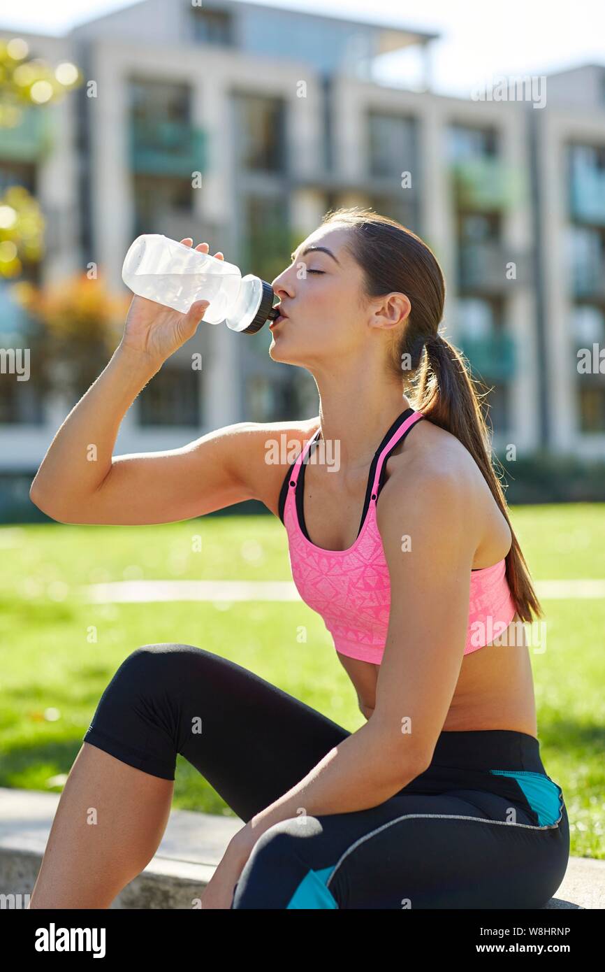 Junge Frau trinkt aus der Wasserflasche. Stockfoto