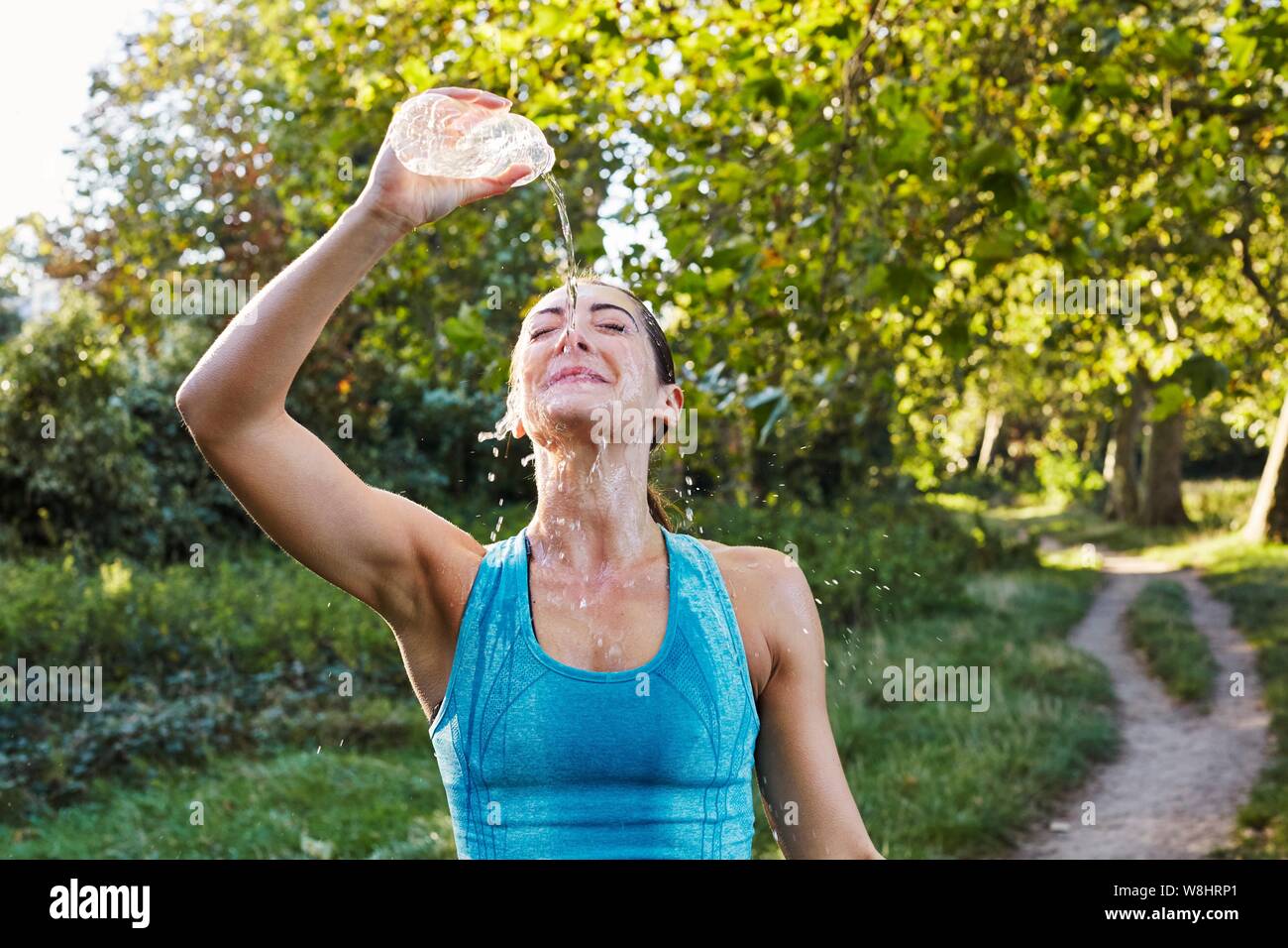 Junge Frau gießt Wasser über ihr Gesicht. Stockfoto