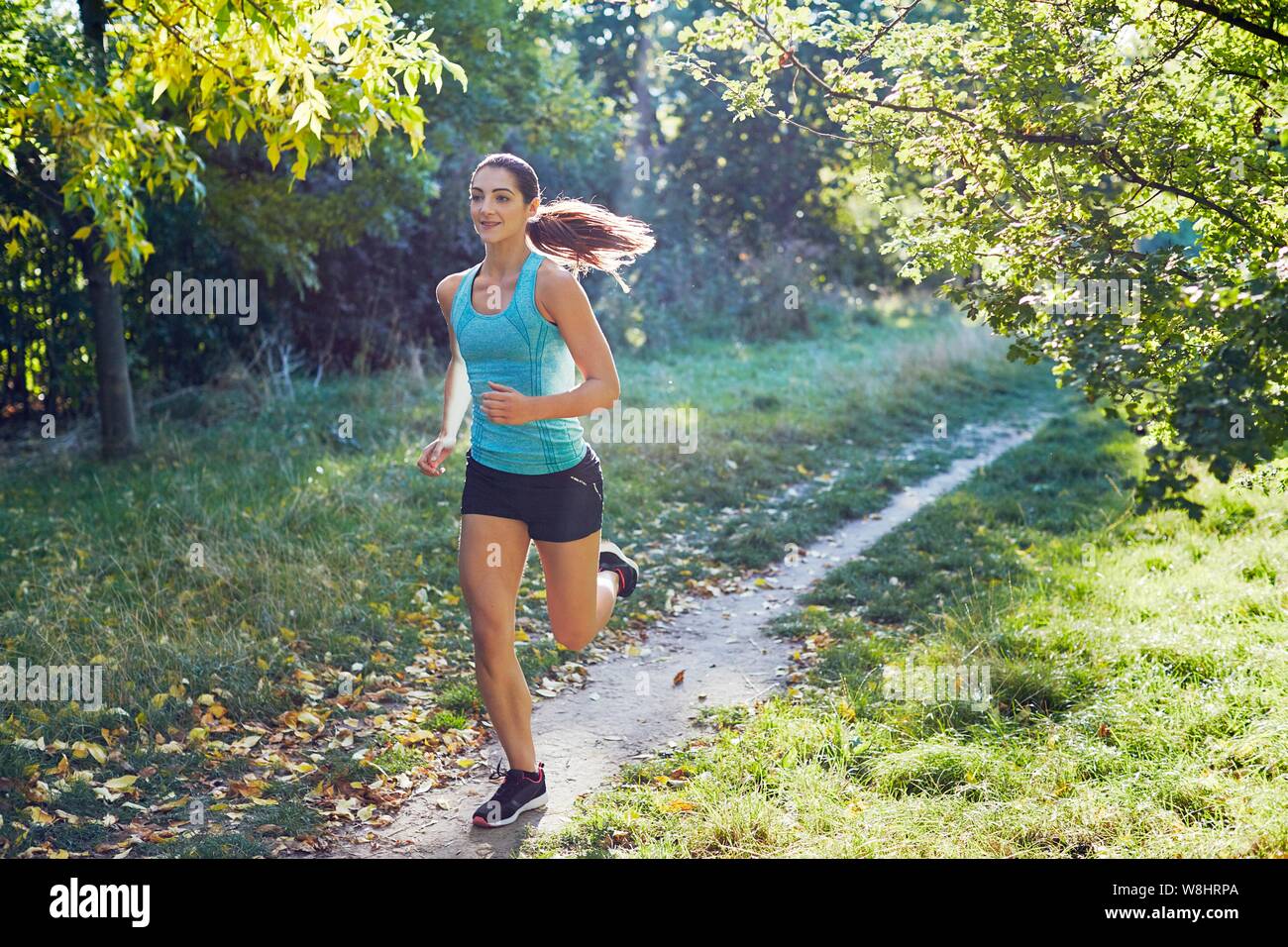 Junge Frau joggen auf Pfad. Stockfoto