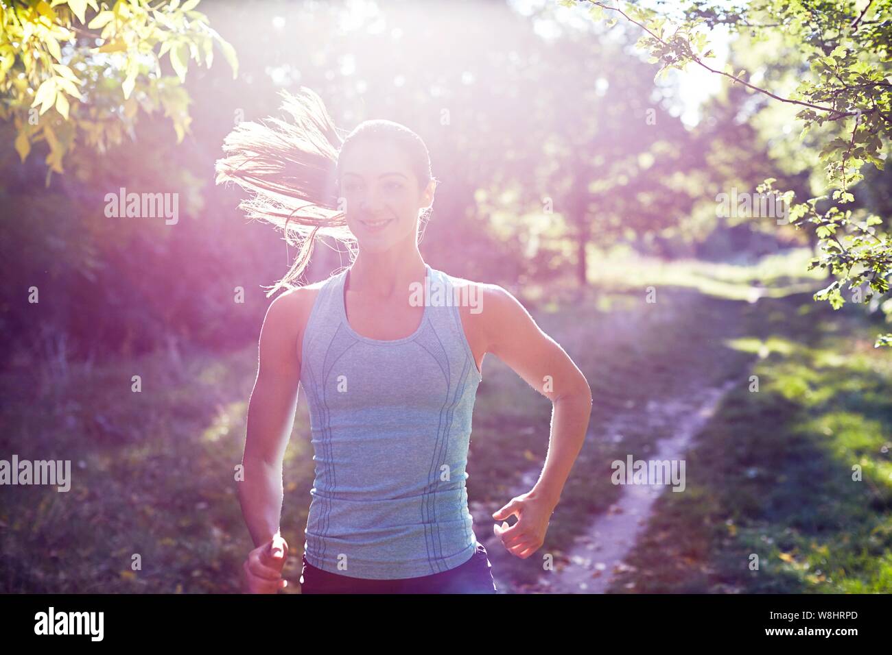 Junge Frau joggen auf Pfad. Stockfoto