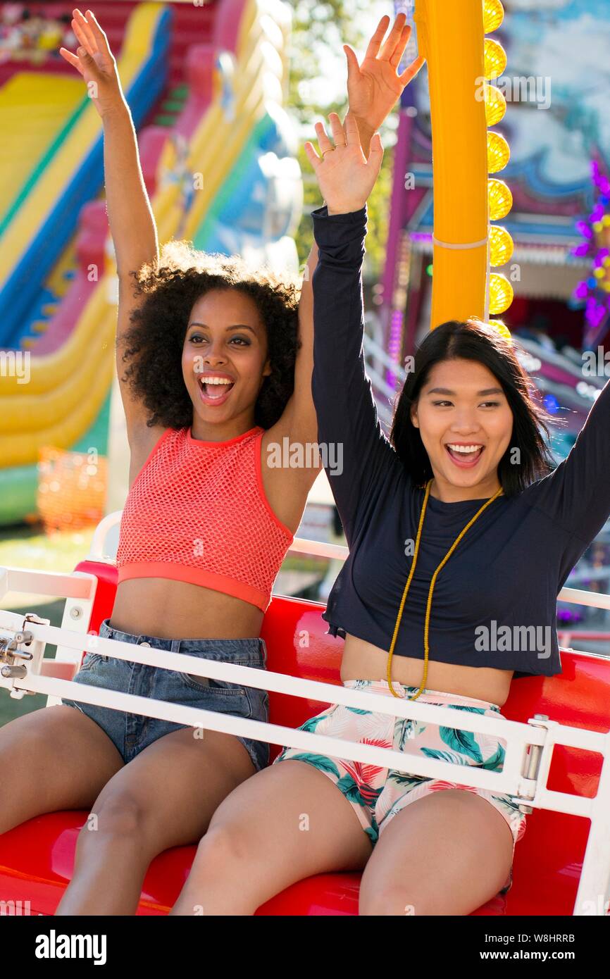 Zwei junge Frauen auf Messe Fahrt am Jahrmarkt. Stockfoto