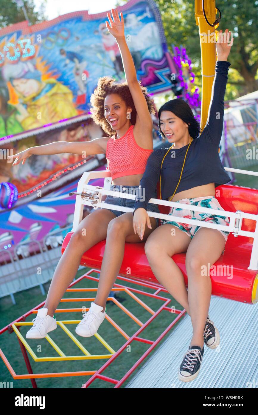 Zwei junge Frauen auf Messe Fahrt am Jahrmarkt. Stockfoto