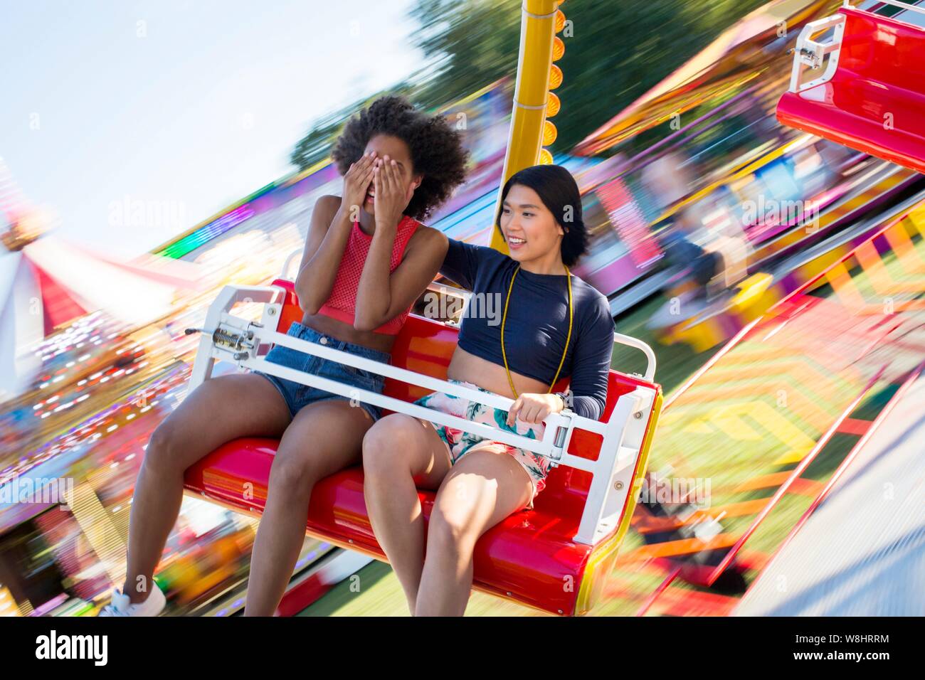 Zwei junge Frauen auf Messe Fahrt am Jahrmarkt. Stockfoto