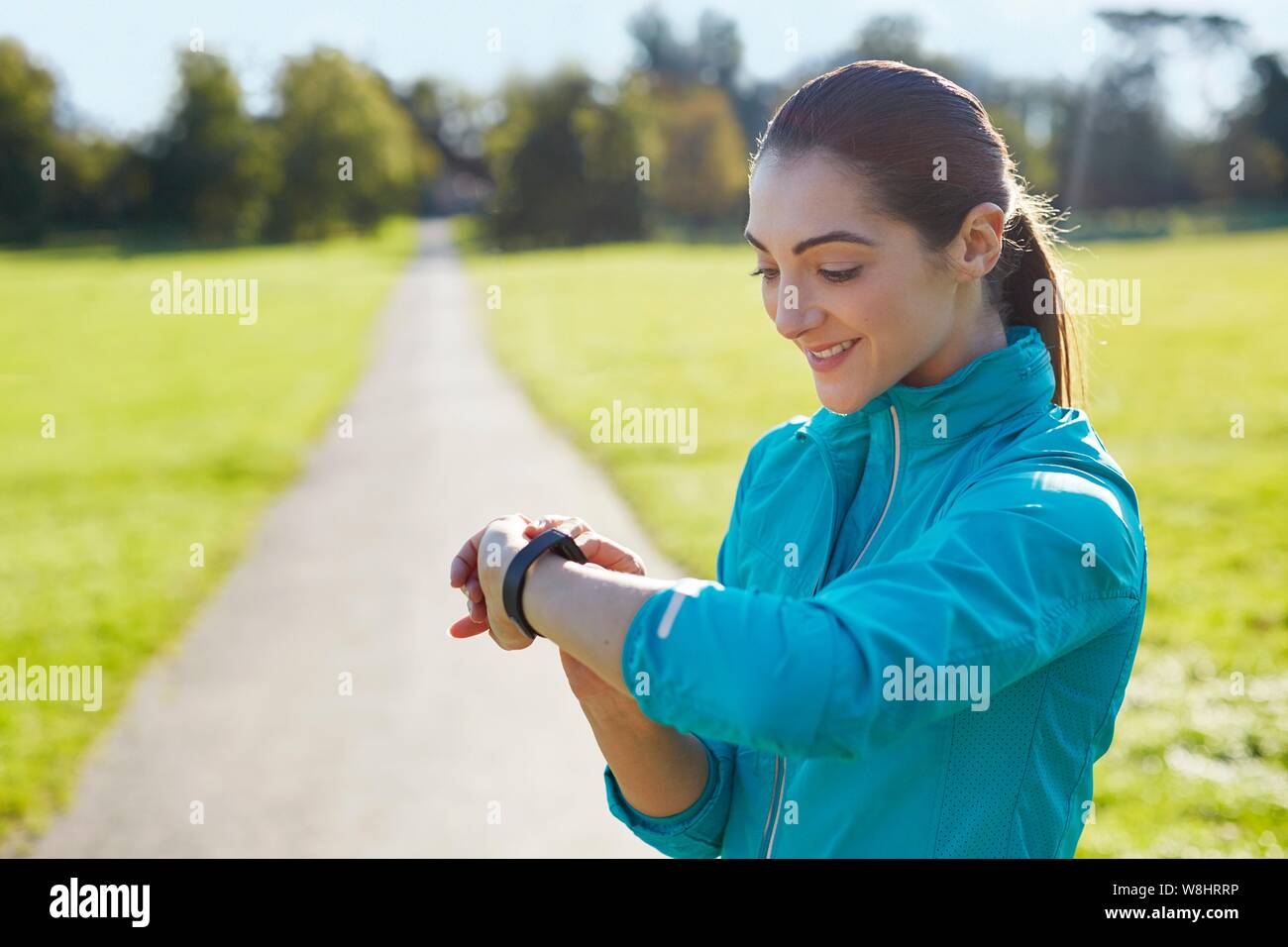 Junge Frau trägt Sport Kleidung Kontrolle ihre Uhr. Stockfoto