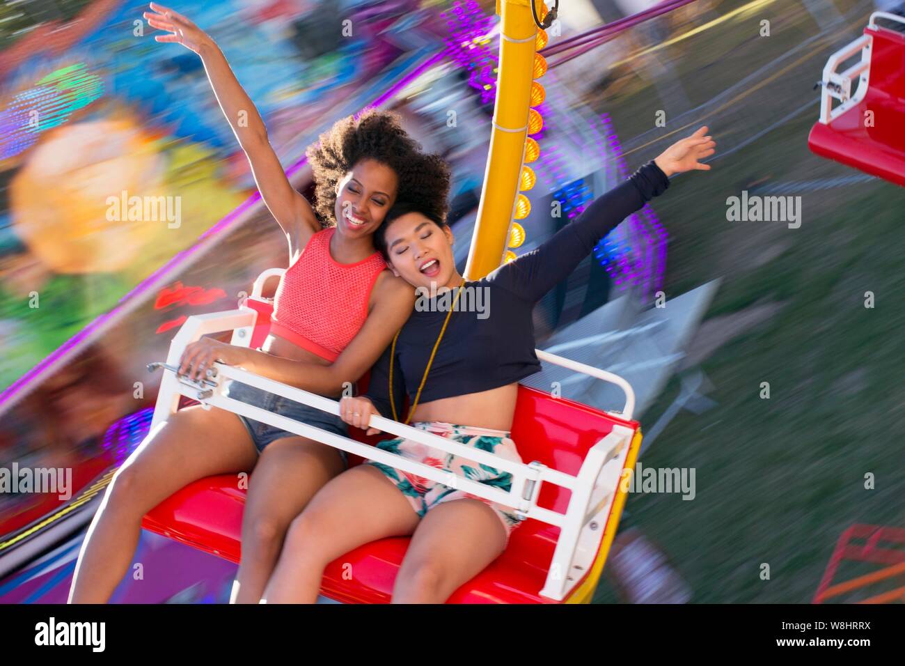 Zwei junge Frauen auf Messe Fahrt am Jahrmarkt. Stockfoto