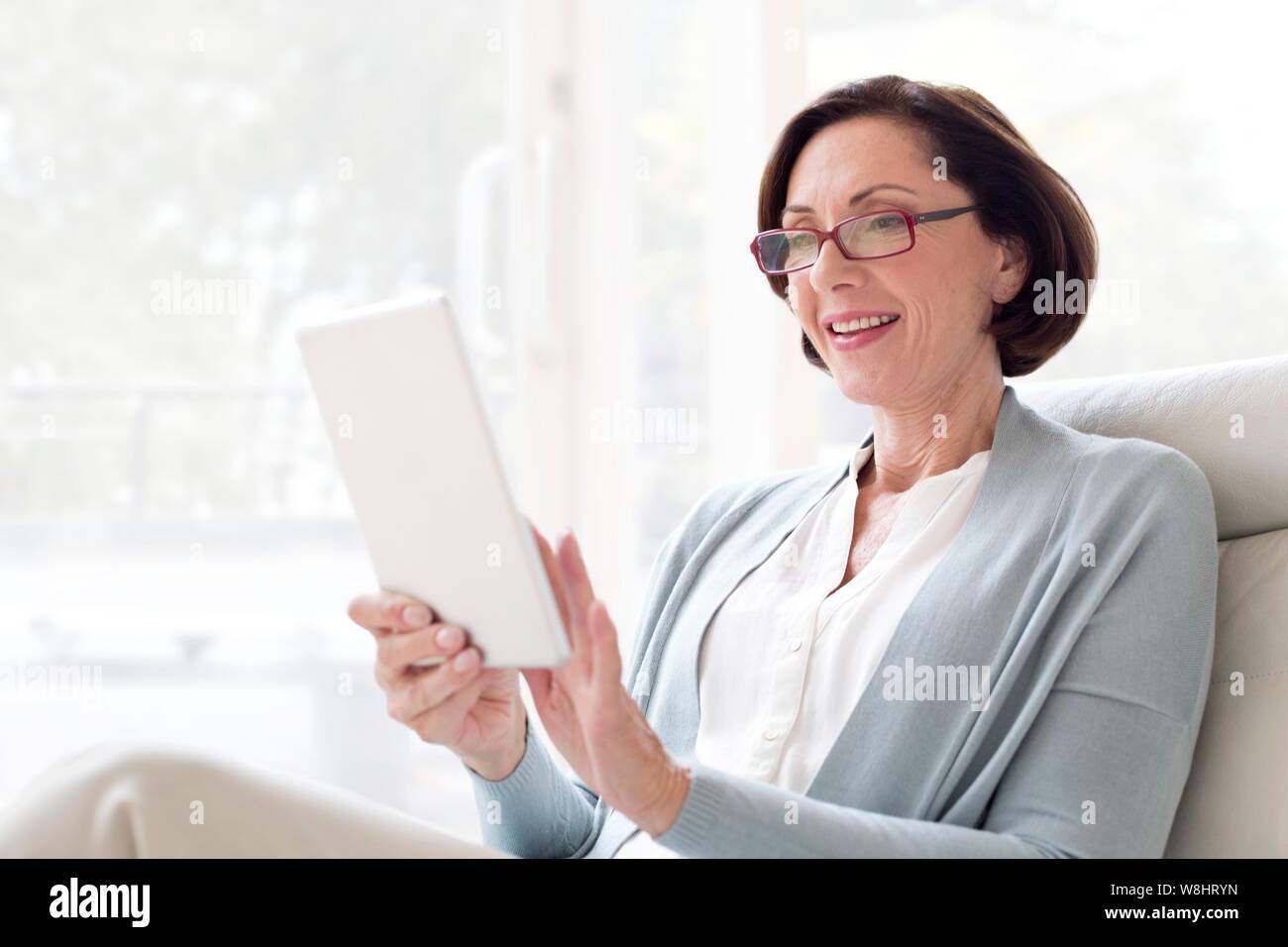 Reife Frau mit digitalen Tablet. Stockfoto