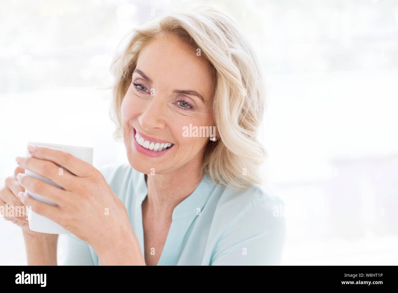Reife Frau lächelnd mit Tasse Tee. Stockfoto