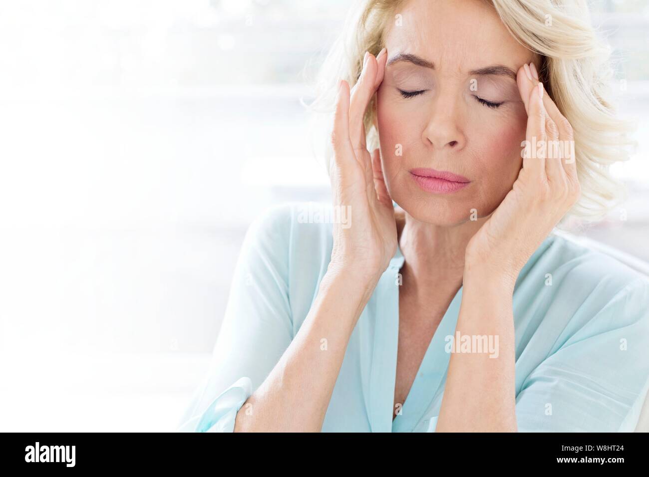 Reife Frau mit Kopfschmerzen. Stockfoto