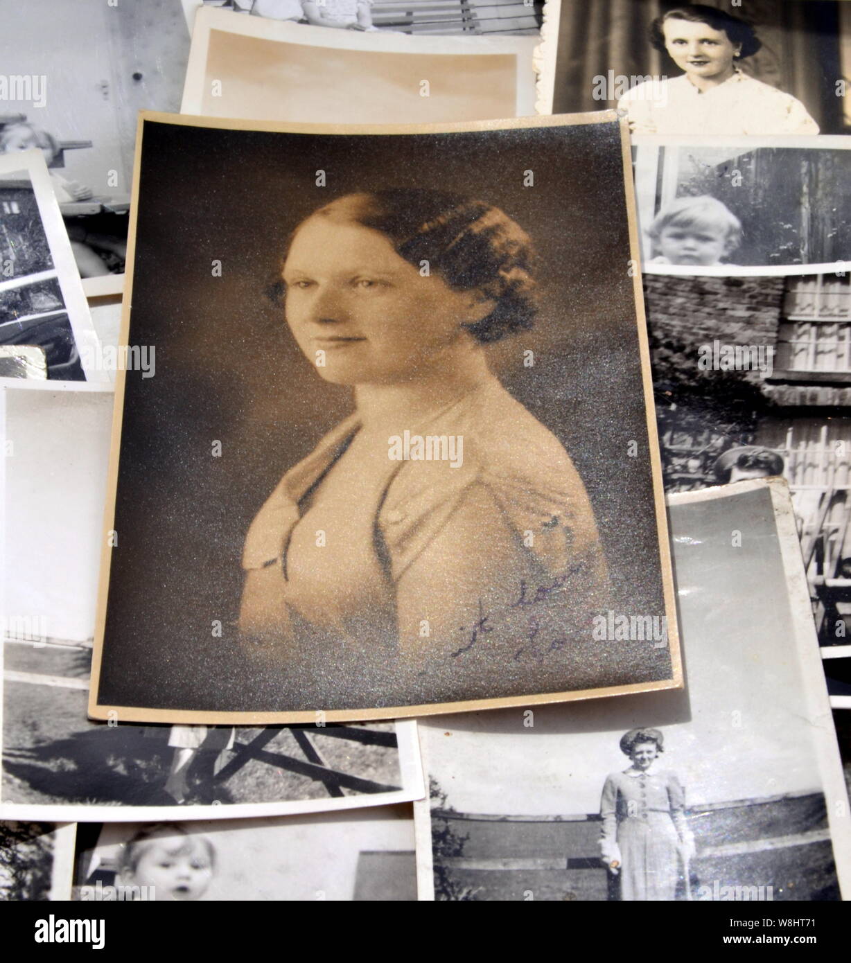 Ein schwarz-weiß Foto einer jungen Frau auf einem Hintergrund von kleiner Schwarzweiß-Fotos Stockfoto